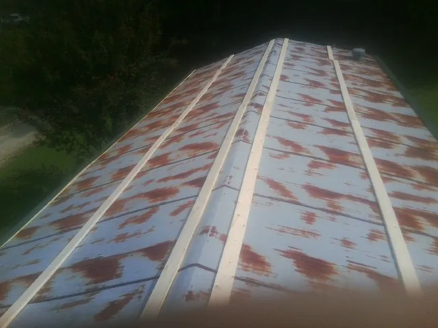 Rusted metal roof panels with new wood purlins before replacement — Storm Damage Roof Repair in Lulu by Roofing Brothers