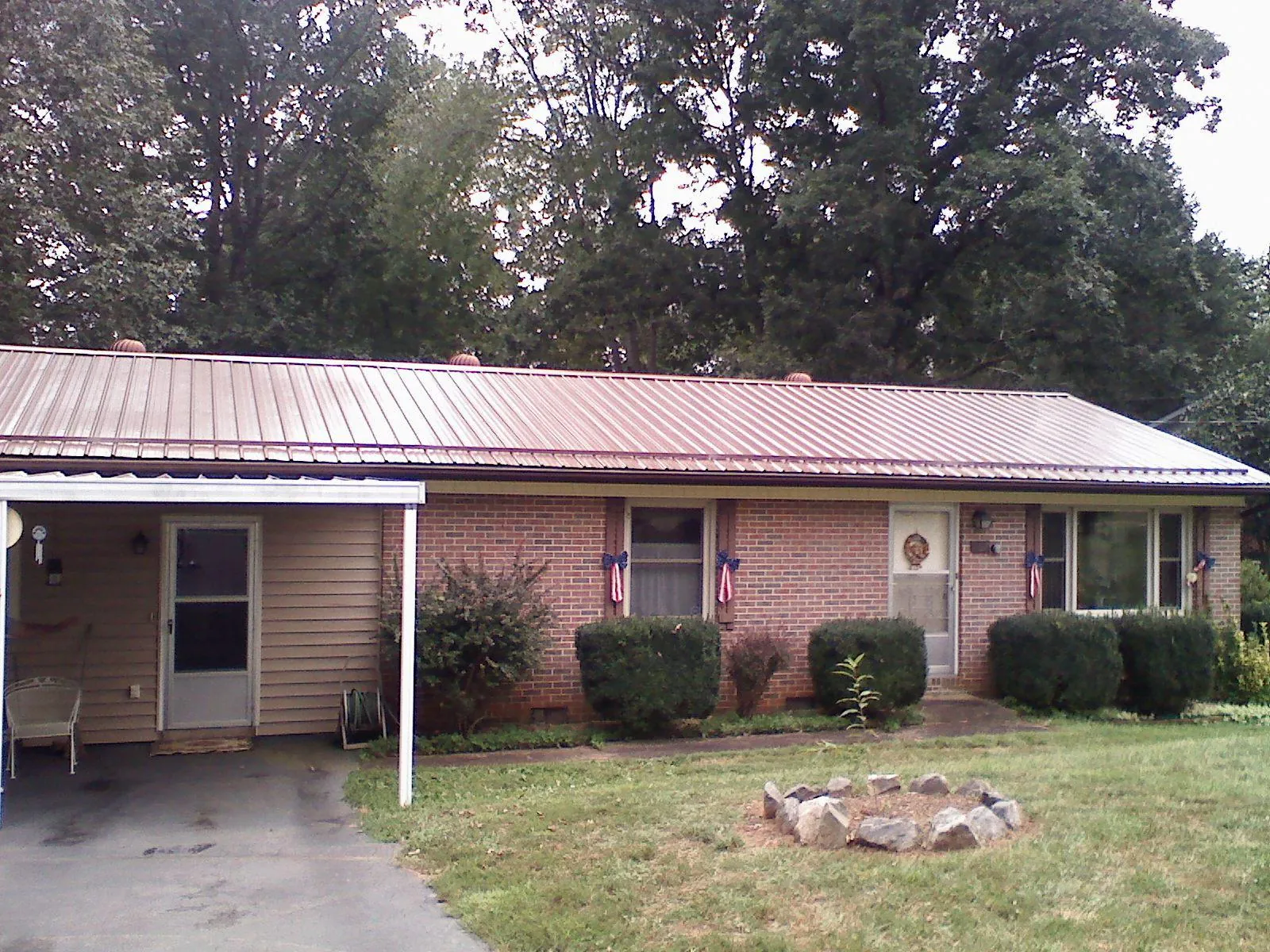 Bronze metal roof and carport on a brick ranch home — Roof Repair work by our crew in Lulu